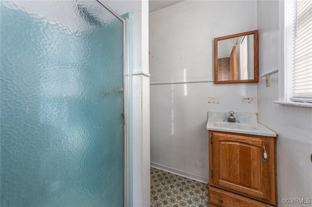 bathroom featuring tile walls, vanity, and a shower with door