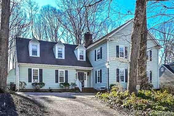 view of front facade with driveway and a chimney