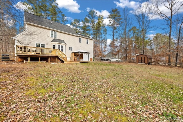 back of house featuring a shed, a deck, and a yard