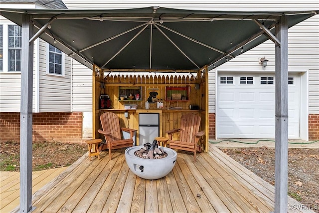 deck featuring a garage and an outdoor fire pit