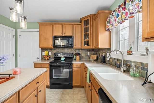 kitchen with sink, black appliances, tasteful backsplash, and decorative light fixtures