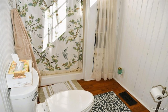 bathroom with toilet, a shower stall, visible vents, and wood finished floors