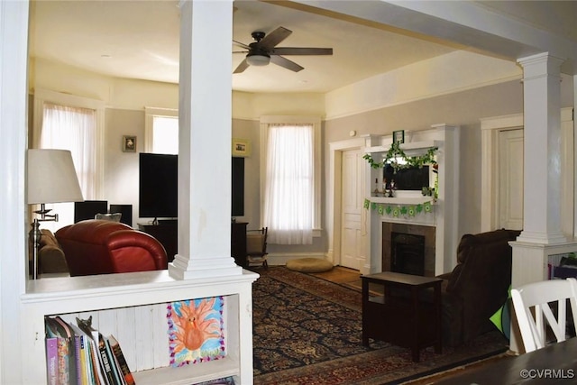 living room featuring decorative columns, a fireplace, and ceiling fan