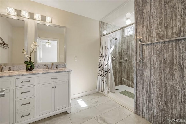 full bathroom featuring double vanity, marble finish floor, tiled shower, and a sink