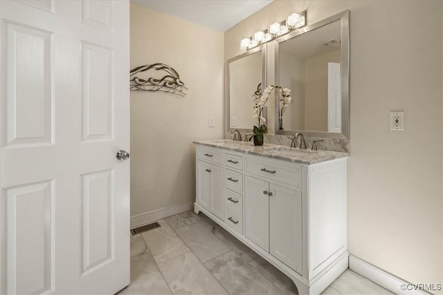 bathroom featuring baseboards, visible vents, double vanity, a sink, and marble finish floor