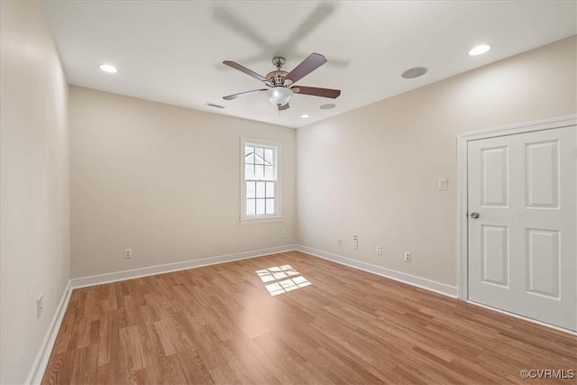 unfurnished room with a ceiling fan, light wood-style floors, visible vents, and baseboards