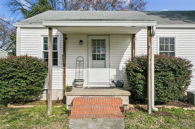 property entrance with a shingled roof and central air condition unit