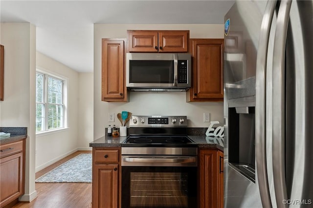 kitchen featuring appliances with stainless steel finishes and light hardwood / wood-style flooring