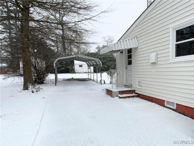 snowy yard featuring a carport