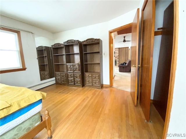 bedroom featuring wood-type flooring and a baseboard heating unit