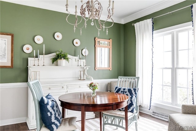 dining area with a notable chandelier, crown molding, and wood-type flooring