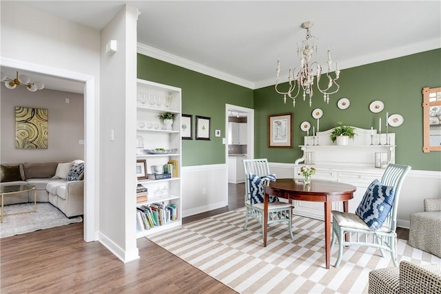 interior space with hardwood / wood-style flooring, ornamental molding, and a chandelier