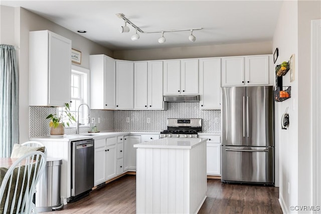 kitchen featuring a kitchen island, sink, stainless steel appliances, and white cabinetry