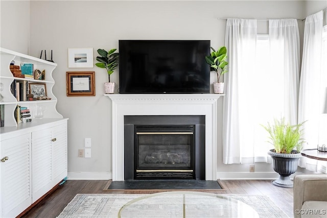 living room with a wealth of natural light and dark wood-type flooring