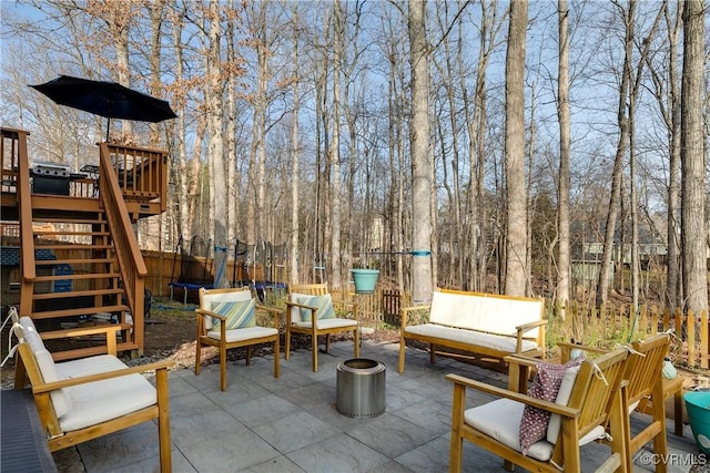 view of patio / terrace with a trampoline and a wooden deck