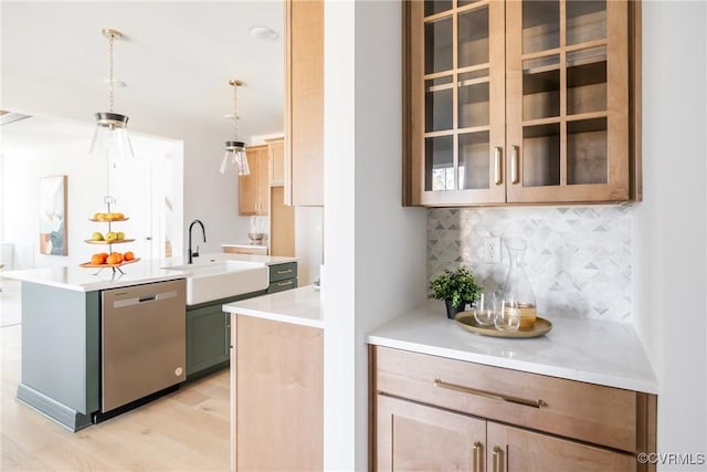 kitchen featuring a kitchen island with sink, decorative light fixtures, sink, tasteful backsplash, and dishwasher