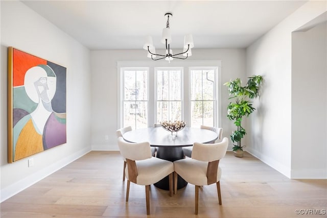 dining room with an inviting chandelier and light hardwood / wood-style flooring