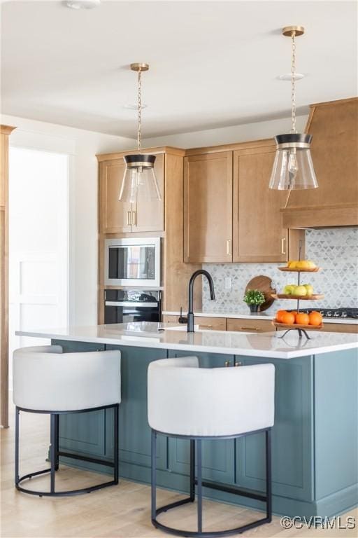 kitchen with a kitchen breakfast bar, stainless steel appliances, decorative backsplash, light hardwood / wood-style floors, and pendant lighting