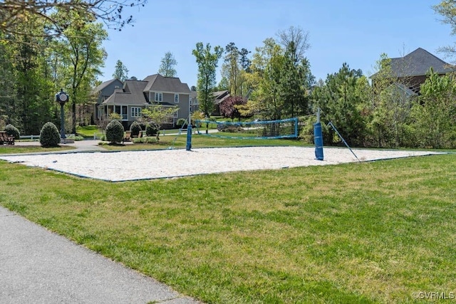 view of community with volleyball court and a lawn