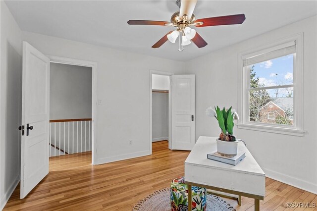 office area with light wood-style flooring, baseboards, and ceiling fan