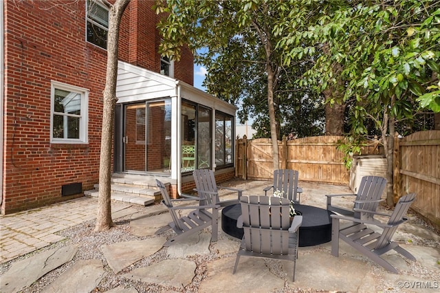 view of patio / terrace with entry steps, a sunroom, and fence