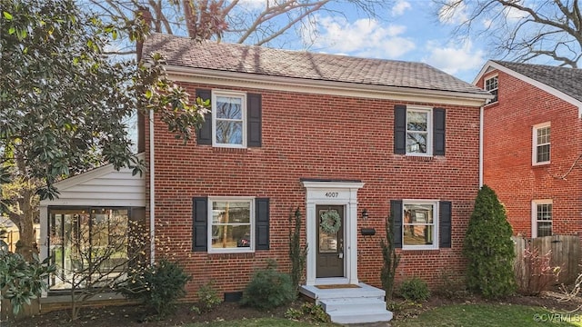 colonial home featuring brick siding