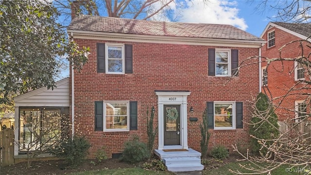 colonial home featuring brick siding