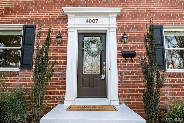 view of exterior entry featuring brick siding