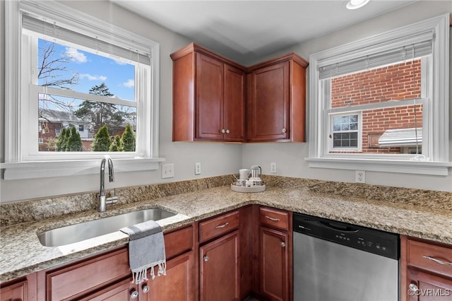 kitchen with a sink, light stone countertops, brown cabinetry, and stainless steel dishwasher