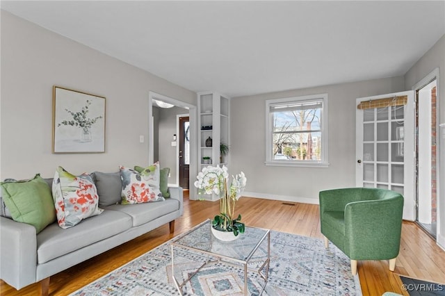 living area with baseboards and wood finished floors