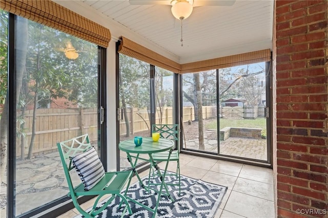 unfurnished sunroom featuring ceiling fan