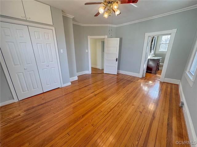 unfurnished bedroom featuring light hardwood / wood-style flooring, ensuite bath, a closet, ceiling fan, and crown molding