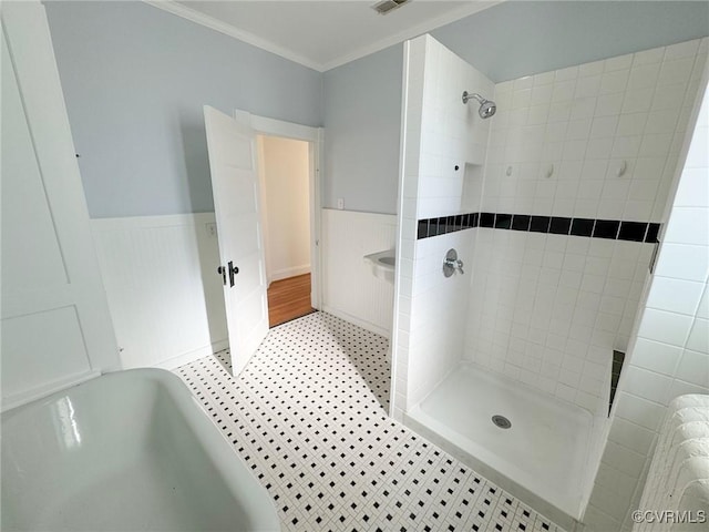 bathroom featuring a tile shower and crown molding