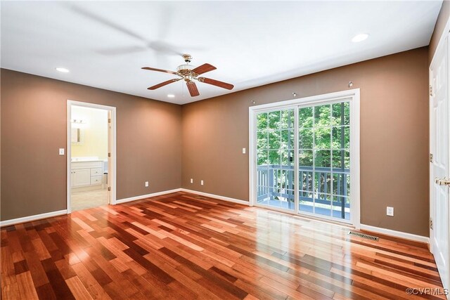 unfurnished room with baseboards, visible vents, and wood finished floors