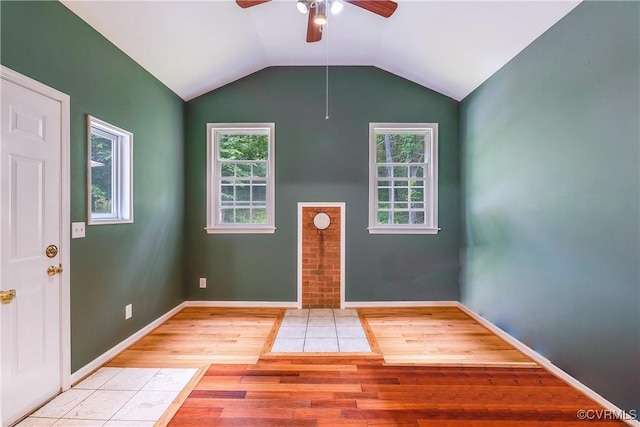 entryway with baseboards, vaulted ceiling, and light wood-type flooring