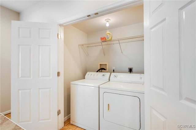 washroom with washing machine and clothes dryer, baseboards, and laundry area