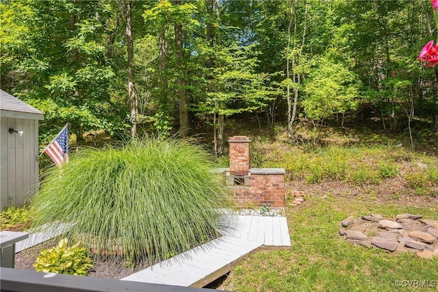 view of yard with an outdoor brick fireplace