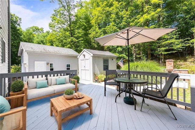 wooden terrace featuring an outdoor structure, outdoor lounge area, and a shed