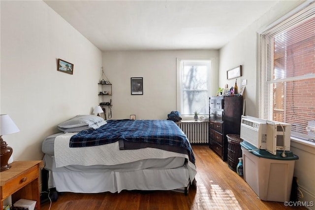 bedroom with radiator and wood finished floors