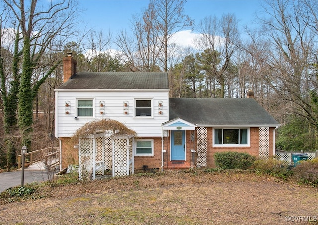 tri-level home featuring brick siding and a chimney