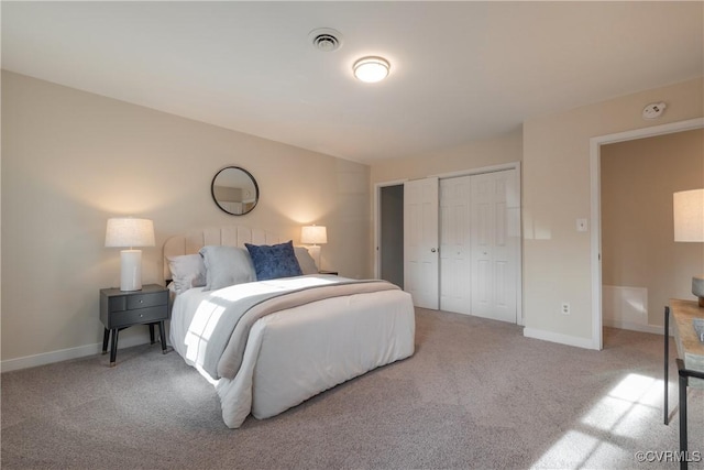 bedroom featuring baseboards, visible vents, a closet, and light colored carpet