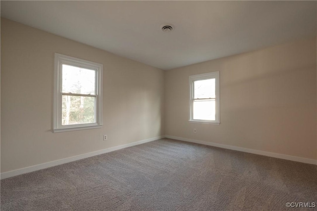 carpeted empty room with visible vents and baseboards