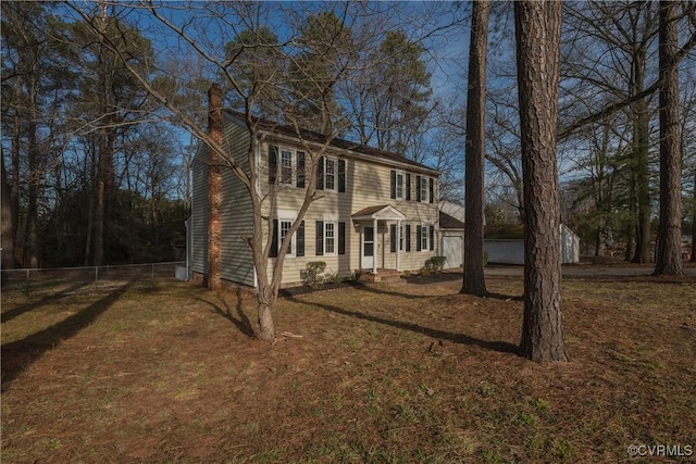 view of front facade featuring a chimney and a front lawn