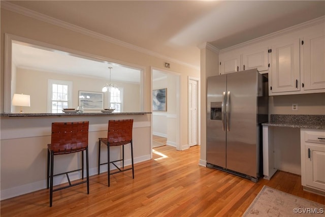 kitchen with white cabinetry, stainless steel refrigerator with ice dispenser, light wood finished floors, and light stone countertops