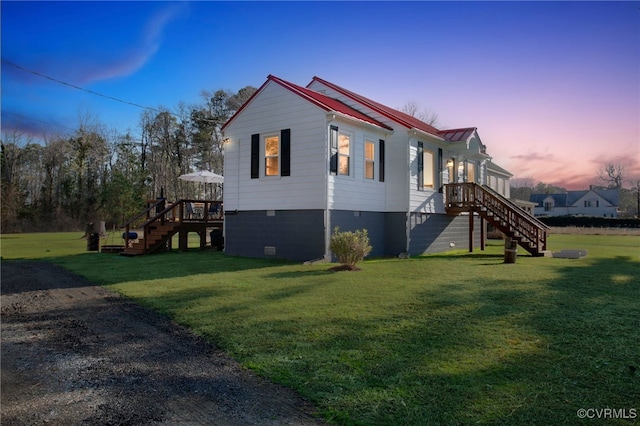 view of side of property featuring stairs, metal roof, and a lawn