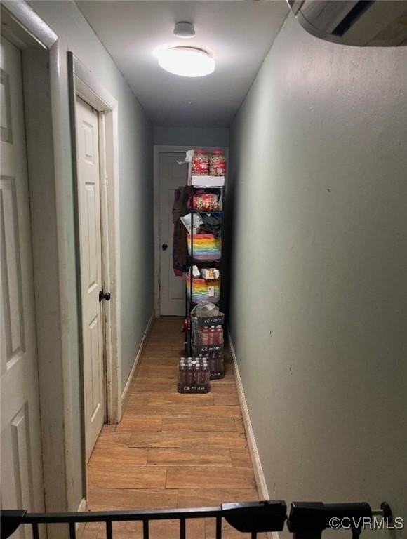 corridor with light wood finished floors and baseboards