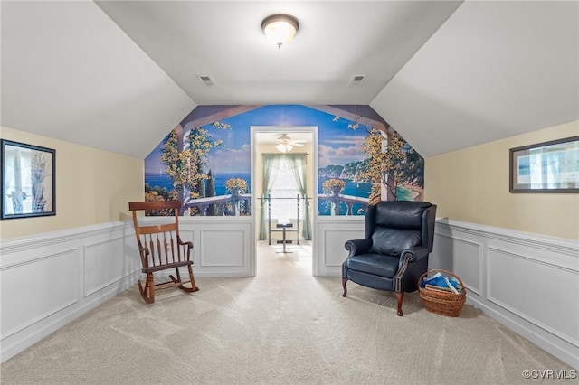 sitting room featuring vaulted ceiling, wainscoting, carpet flooring, and visible vents