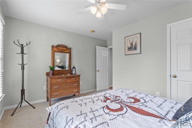 bedroom featuring baseboards, ceiling fan, and light colored carpet