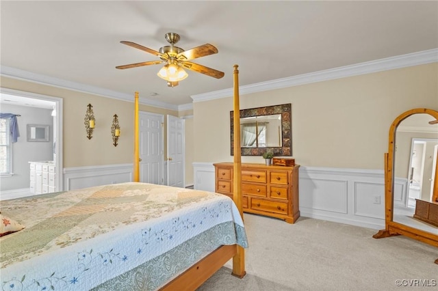 bedroom featuring wainscoting, light carpet, and crown molding