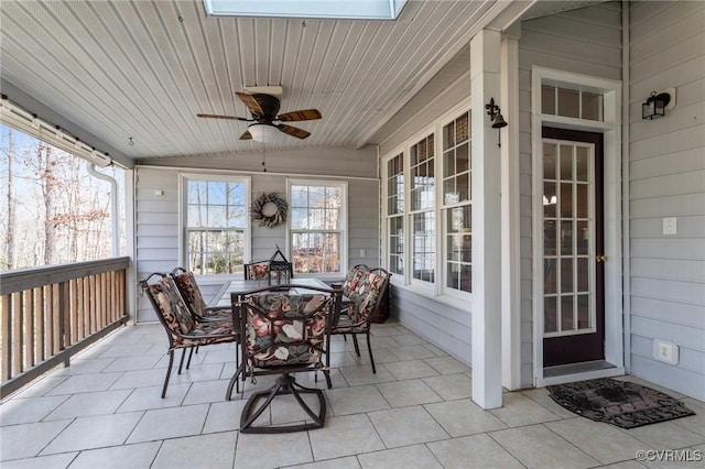 sunroom / solarium with lofted ceiling with skylight, wood ceiling, and a ceiling fan